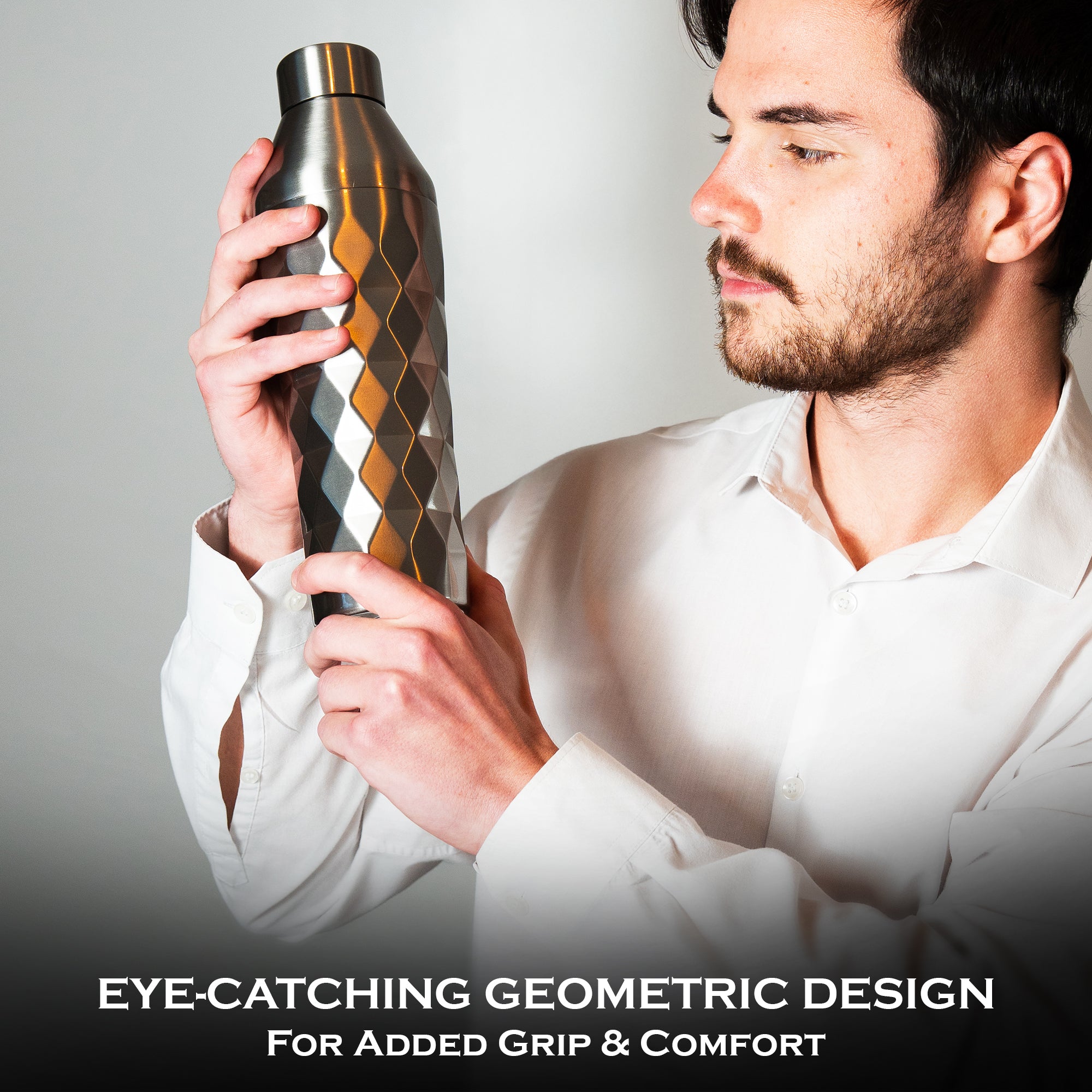 Man holding a metallic cocktail shaker with geometric design against a gray background